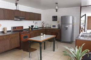 a kitchen with a table and a refrigerator at Casa San Antonio in Aguascalientes