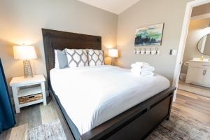 a bedroom with a large white bed and a mirror at Colony Suites in Palmer
