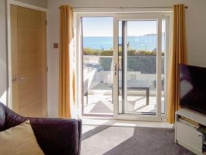 a living room with a sliding glass door at Beach Cottage in Benllech