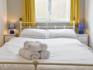 a bedroom with two beds with towels on it at Beach Cottage in Benllech