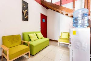 ein Wohnzimmer mit einem grünen Sofa und einem Kühlschrank in der Unterkunft Private bedroom 10 minutes from the SJO airport in Alajuela