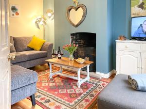 sala de estar con mesa de centro y chimenea en Wisteria Cottage, en Uppingham