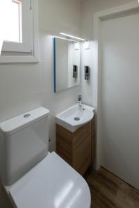 een badkamer met een toilet, een wastafel en een spiegel bij El mirador del Mentidero in Cádiz
