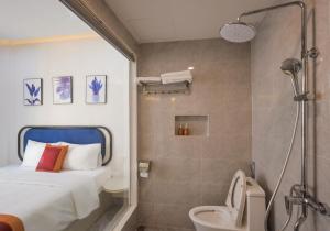 a bathroom with a bed and a shower and a toilet at Hai Duong PQ Hotel in Phu Quoc