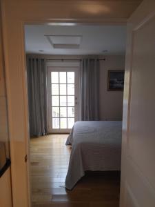 um quarto com uma cama e uma janela grande em Borough Beach Apartment em Stonington