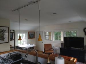 uma cozinha com televisão e uma sala de estar em Borough Beach Apartment em Stonington