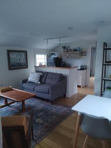 a living room with a couch and a table at Borough Beach Apartment in Stonington