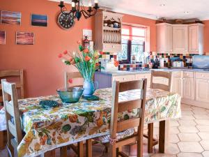 a kitchen with a table with a vase of flowers on it at Rothiemay in Walcott