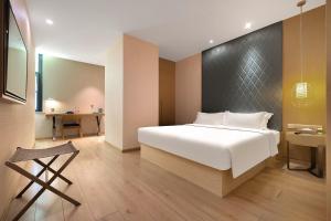 um quarto com uma grande cama branca e uma secretária em Ibis Styles XM Zhongshan Hotel em Xiamen