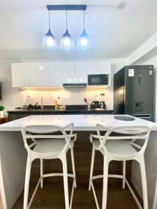 eine Küche mit zwei weißen Stühlen und einer weißen Arbeitsplatte in der Unterkunft Amazing 2BR in Barranco in Lima