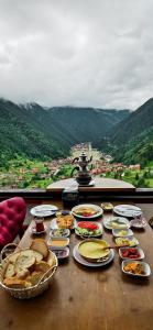 una mesa cubierta con platos de comida en la cima de una montaña en Kar Hotel Uzungöl, en Uzungöl