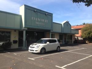 um carro branco estacionado num parque de estacionamento em frente a um edifício em Evancourt Motel Malvern East em Melbourne