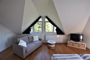a living room with a couch and a tv at Wellenreiter-App-8-H in Hohwacht
