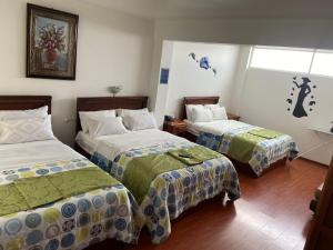 a hotel room with two beds and a window at Loreto hotel in Latacunga