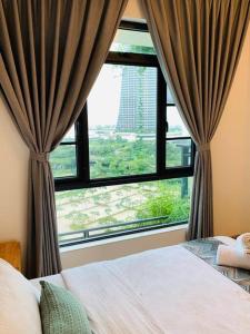 een slaapkamer met een raam met uitzicht op een gebouw bij 森林城市 6999 Homestay【小温馨】@ 免税岛 Legoland JB SG in Gelang Patah