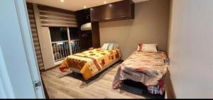 a small bedroom with two beds and a window at Centro de Tarija departamento independiente completo in Tarija