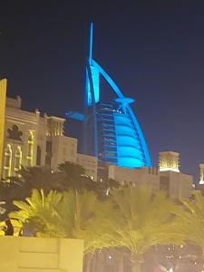 a view of a building with a blue building at night at Sunrise Dubai in Dubai