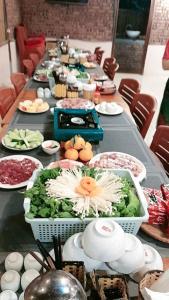 długi stół z wieloma talerzami jedzenia na nim w obiekcie Mai Chau Green house w mieście Mai Châu