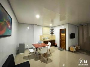 Dapa的住宿－ZM Residence，一间带桌子和白色椅子的用餐室
