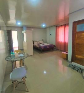 a bedroom with a bed and a table and a chair at ZM Residence in Dapa