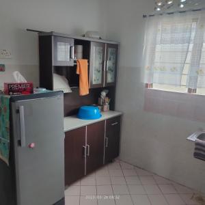 a small kitchen with a refrigerator and a sink at Sri Bayu Bidara Palma in Masjid Tanah