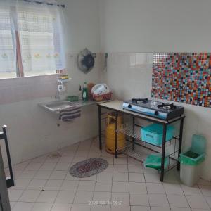 a small kitchen with a sink and a stove at Sri Bayu Bidara Palma in Masjid Tanah