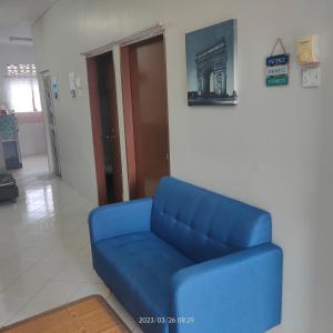 un sofá azul sentado en una habitación con puerta en Sri Bayu Bidara Palma, en Masjid Tanah