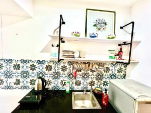a kitchen with a sink and a counter with a tile wall at Duplex WARM HANOI, 2 bedrooms, Old Quarter, 3mins to Hoan Kiem Lake in Hanoi