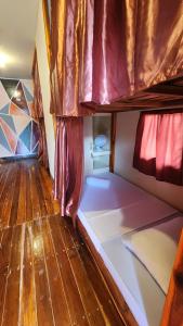 a room with a bunk bed and a wooden floor at Dam Dam Hostel in San Vicente