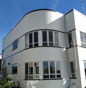 a white house with a curved roof at CBD Apartment, River View in Hamilton