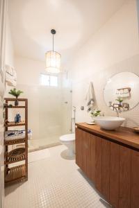 a bathroom with a sink and a toilet and a mirror at Casa Kala "Uma experiência beira-mar" in Porto De Galinhas