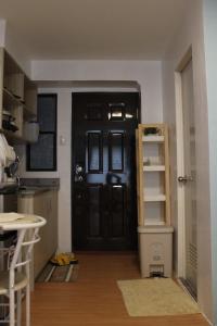 una cocina con una puerta negra y un estante en Happy Dwellers en Marilao