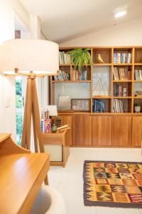 a living room with a desk and book shelves at Casa Kala "Uma experiência beira-mar" in Porto De Galinhas
