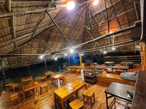 um quarto amplo com mesas e cadeiras de madeira em Dam Dam Hostel em San Vicente