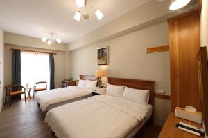 een hotelkamer met 2 bedden en een tafel bij Looksea in Hualien