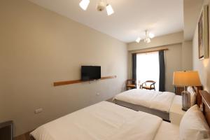 een hotelkamer met 2 bedden en een flatscreen-tv bij Looksea in Hualien