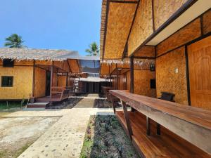 un edificio con bancos de madera delante en Dam Dam Hostel, en San Vicente