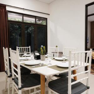 a white dining room with a white table and chairs at Jatiluhur Valley Resort in Purwakarta