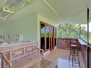 a porch with a bar and chairs in a house at Tiny House Gianyar in Gianyar