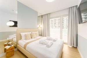 a bedroom with a bed with towels on it at POLANKI AQUA APARTAMENTY - Family Pool & Wellness in Kołobrzeg +89 photos