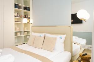 1 dormitorio con 1 cama con sábanas y almohadas blancas en POLANKI AQUA en Kołobrzeg