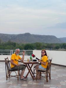 two people sitting at a table on a patio at Hotel Saif Ranthambhore in Sawāi Mādhopur