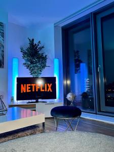 einen TV mit dem Netflix-Schild in einem Wohnzimmer in der Unterkunft Salford Quays Apartment, Manchester in Manchester