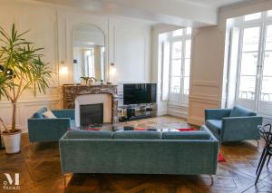 salon z niebieskimi kanapami i kominkiem w obiekcie Appartement design au coeur de Rennes w mieście Rennes