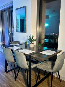 a dining room table with chairs and a mirror at Salford Quays Apartment, Manchester in Manchester