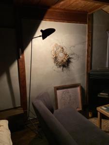 a living room with a floor lamp and a couch at 六根ゲストハウス Rokkon guest house in Kyoto