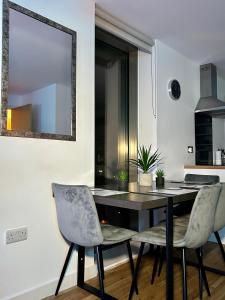 uma sala de jantar com uma mesa e duas cadeiras em Salford Quays Apartment, Manchester em Manchester