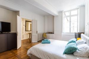 biała sypialnia z dużym łóżkiem i telewizorem w obiekcie Appartement design au coeur de Rennes w mieście Rennes