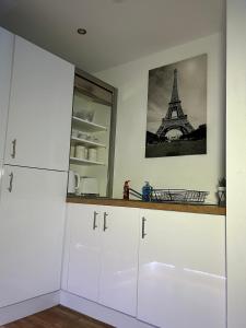 a kitchen with white cabinets and the eiffel tower at Salford Quays Apartment, Manchester in Manchester