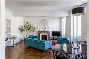 salon z niebieską kanapą i stołem w obiekcie Appartement design au coeur de Rennes w mieście Rennes